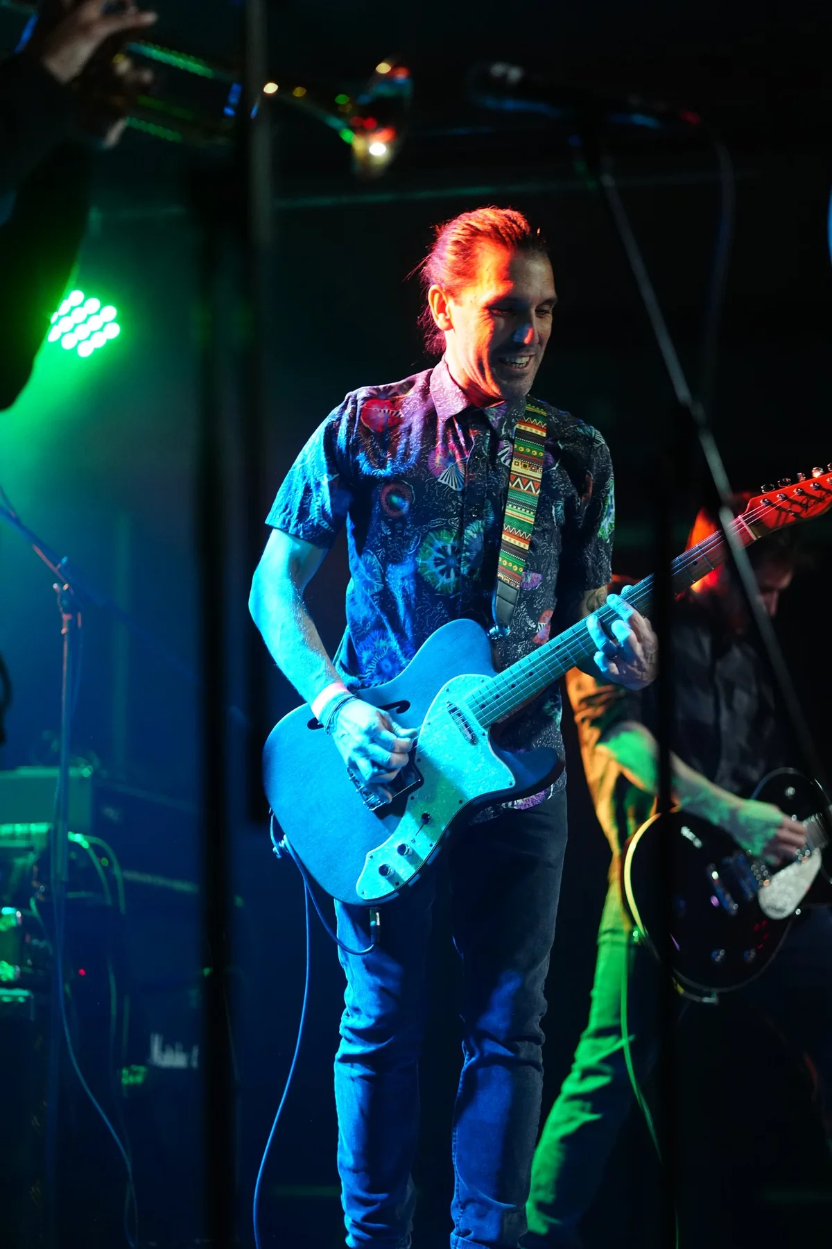 Gerard tocando la guitarra bajo luces azules